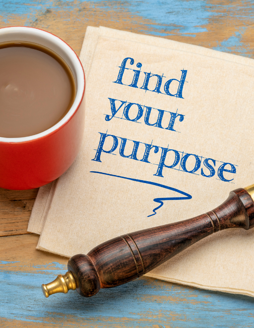 Ein Foto zeigt einen Planung-Stoff mit der Botschaft "find your purpose" in blauer Schrift. Rechts daneben liegt ein altmodischer, dunkelbrauner Handgriff eines Siegellacks mit einem goldenen Ende. Oben links ist ein Teil einer roten Tasse mit einem hellen Getränk, vermutlich Kaffee oder Tee, zu sehen. Unter dem Stoff sind die Ecken von zwei alten Büchern sichtbar. Der Hintergrund besteht aus Holzplanken, die blau und abgenutzt wirken.